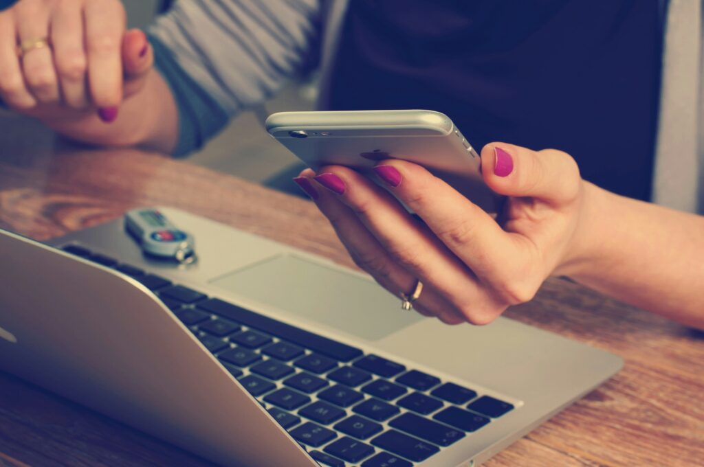 Photo by Firmbee.com on Unsplash Photo of a cell phone and computer to represent phone call mystery shops.